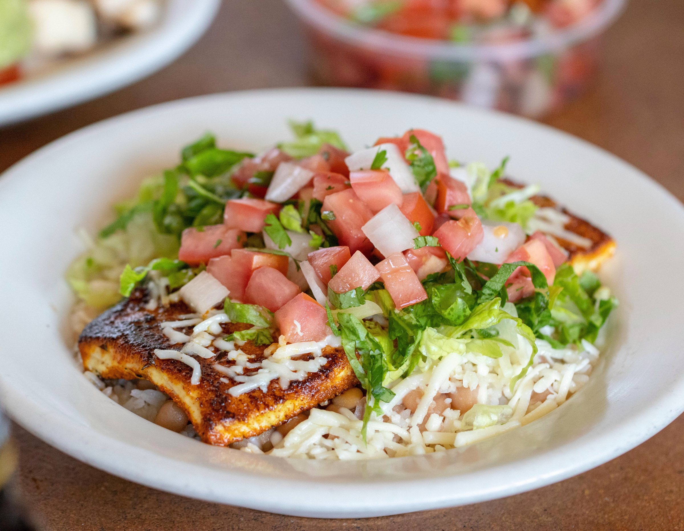 Charbroiled fish taco topped with cabbage and pico de gallo