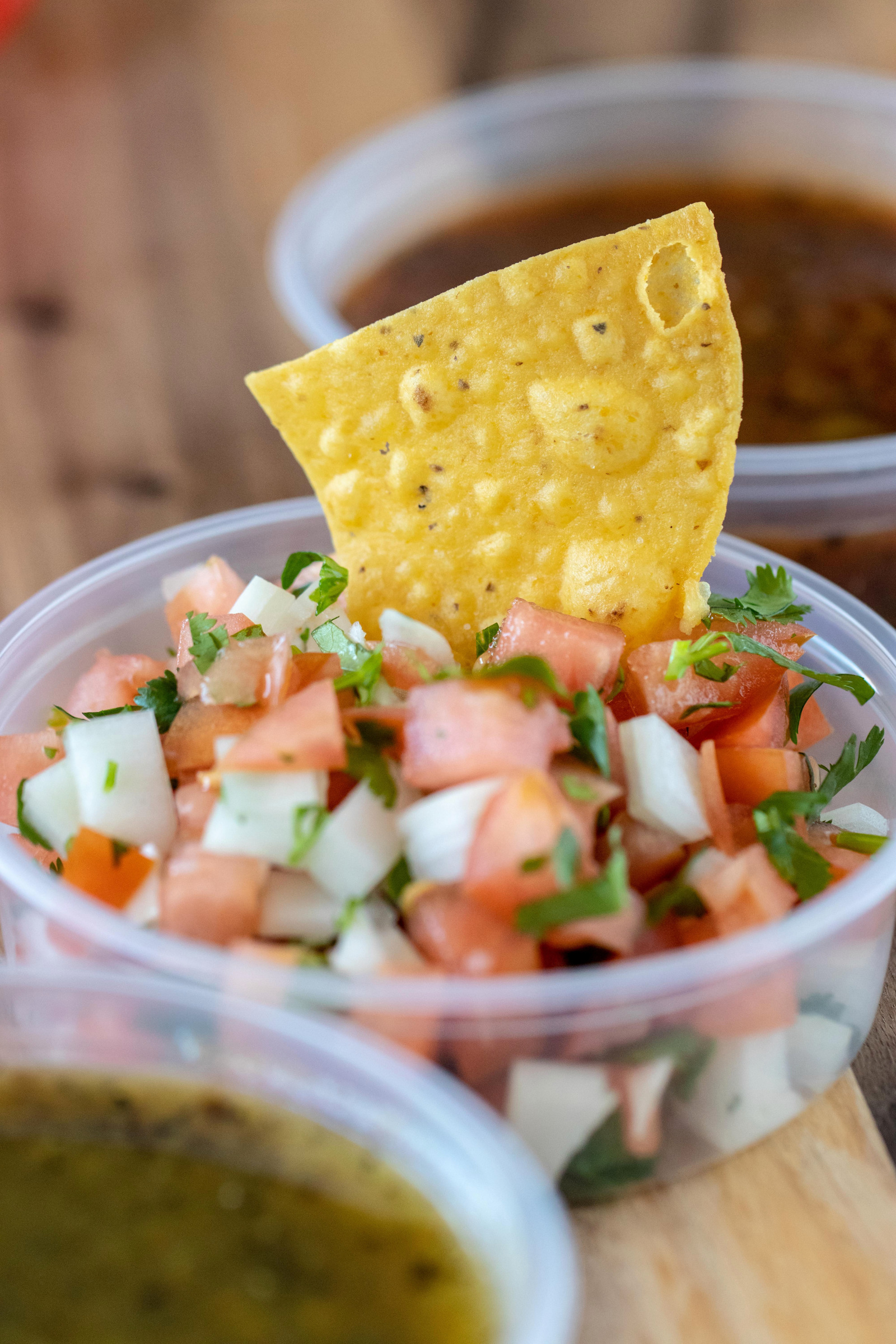 A tortilla chip dipped into freshly prepared Baja salsa